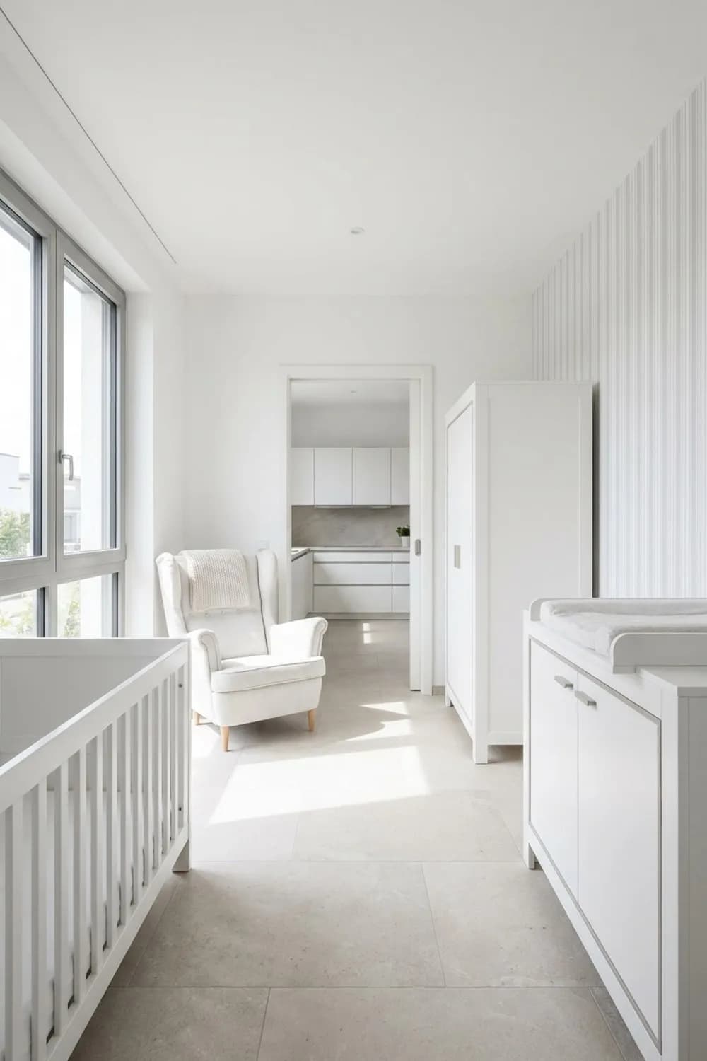 Zeitloser Klassiker: Weiße Möbel, ein bequemer Ohrensessel zum Stillen und zarte Streifentapete – Zimmer für Neugeborene einrichten: 10 schöne Ideen